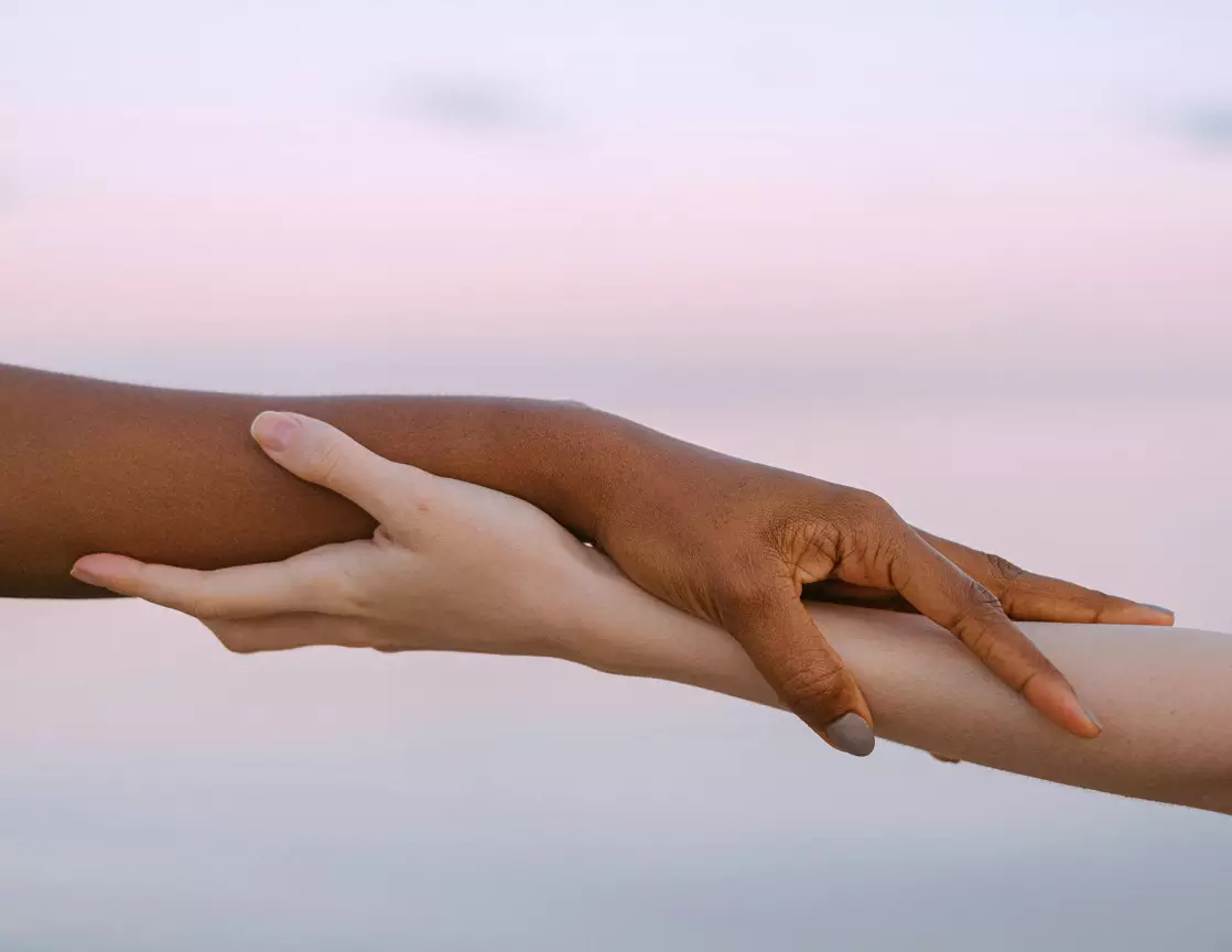 Zwei Hände, die sich sanft halten – Sinnbild für emotionale Unterstützung und Verbindung zwischen Begleitpersonen.