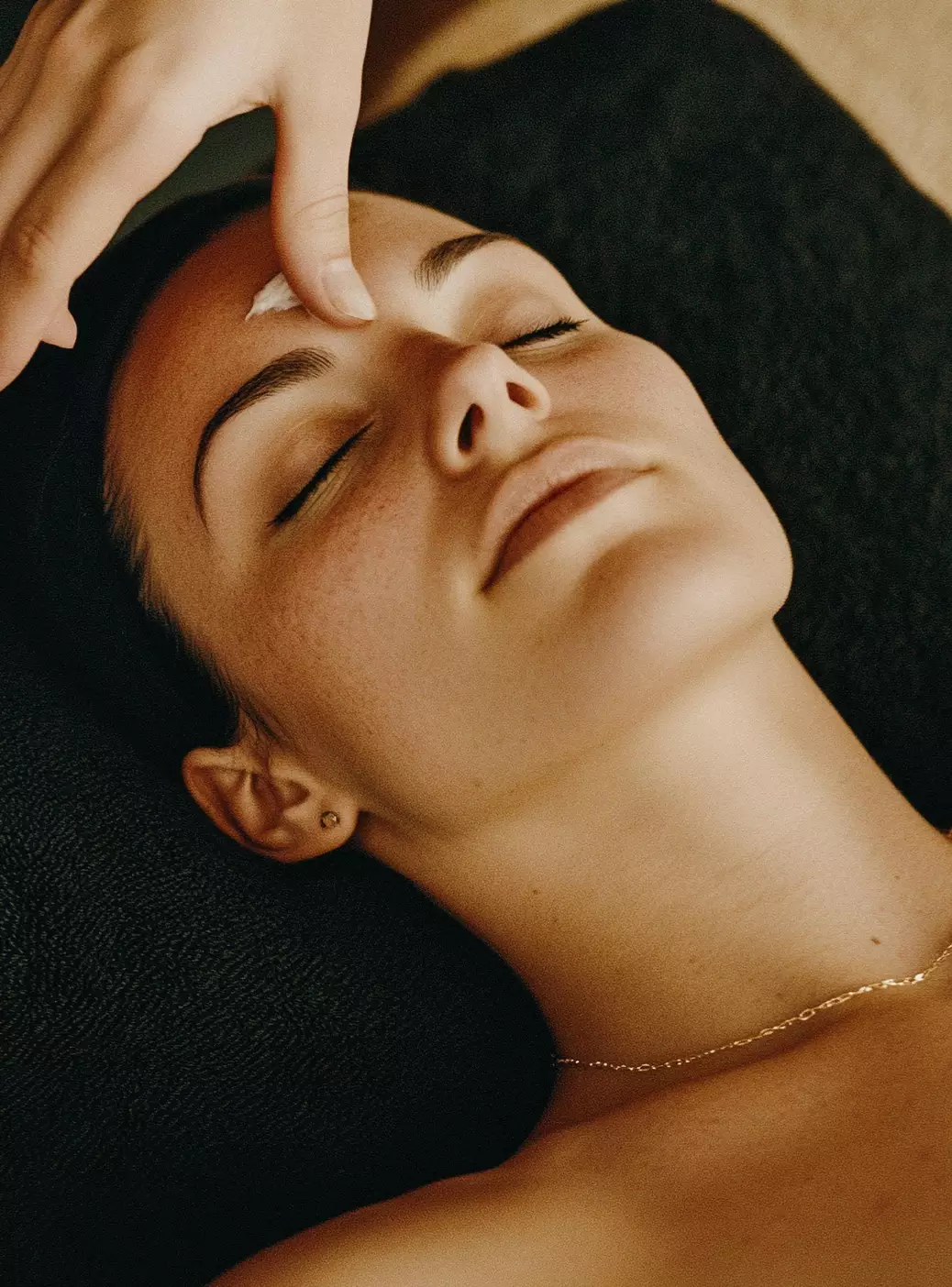 Nahaufnahme einer Person, die eine entspannende Stirnmassage erhält – ein Symbol für Wohlbefinden und Fürsorge für Begleitpersonen.