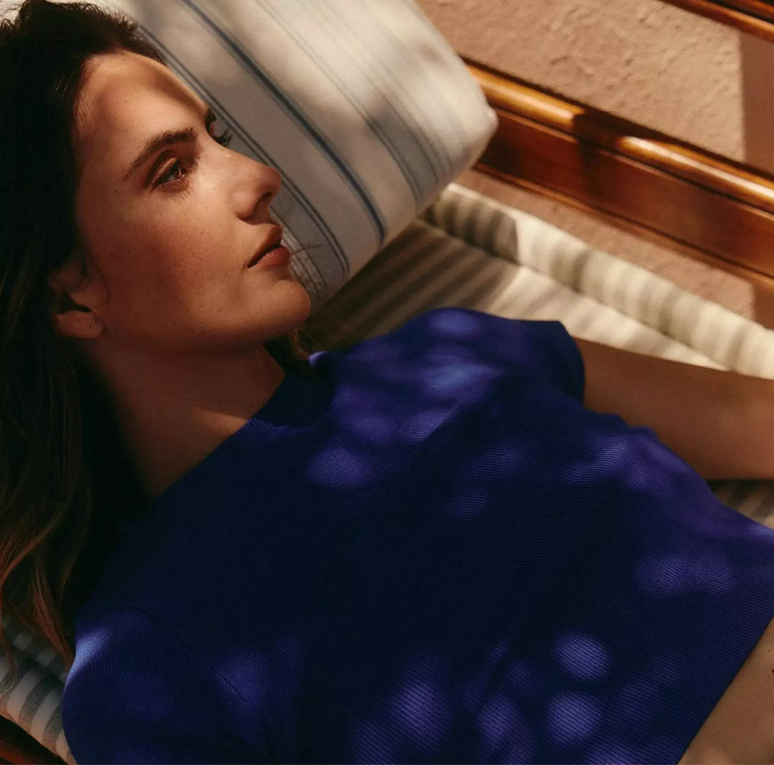 Person, die entspannt auf einer Liege ruht – Sinnbild für Ruhe und Genesung.