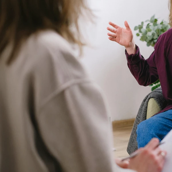 Zwei Personen im Gespräch während einer Therapiesitzung – Symbol für individuelle psychologische Unterstützung.