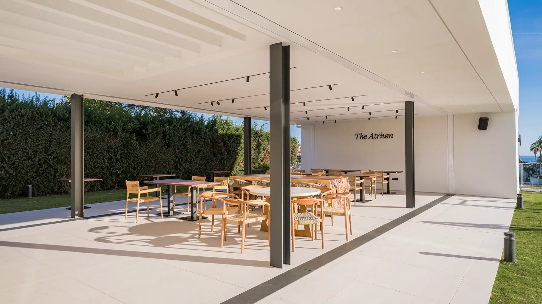 Das Atrium bei Naghoi — überdachte Außenterrasse mit Meerblick, Einrichtung zur postoperativen Erholung an der Costa del Sol.