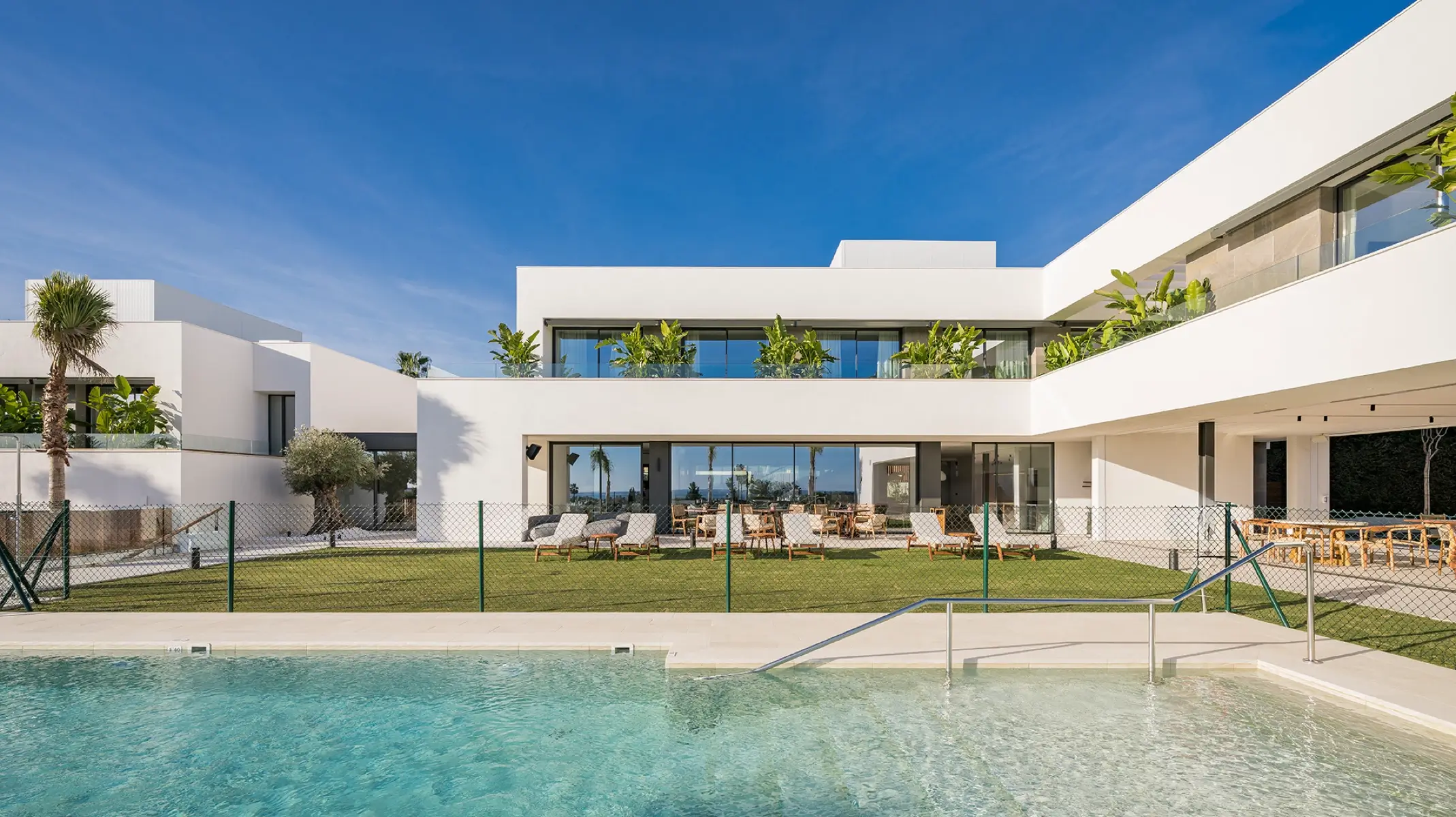 Außenbereich des Naghoi Recovery Sanctuary — Swimmingpool, Gärten und moderne weiße Architektur in Estepona, Spanien.